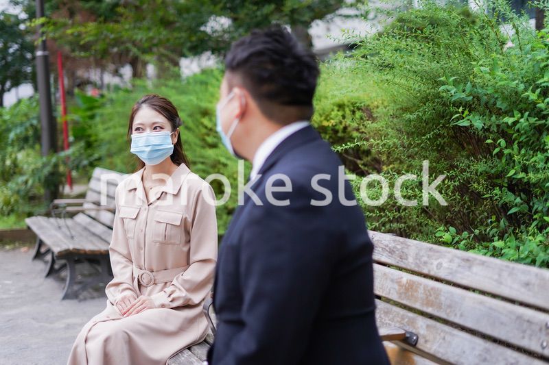 ソーシャルディスタンスを確保して会話をするビジネスパーソン