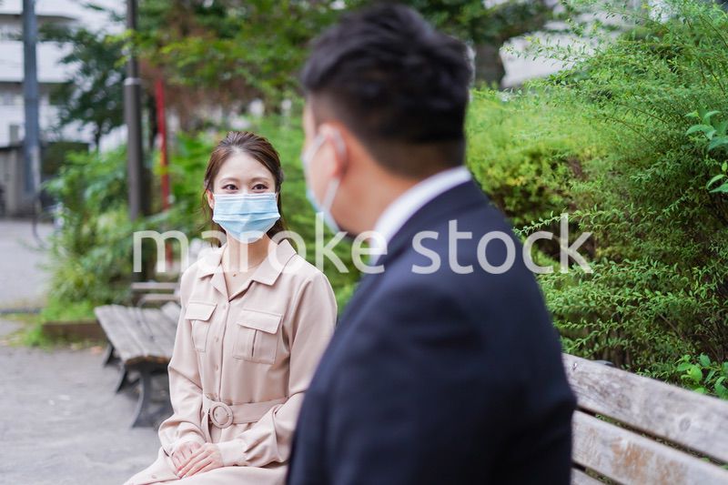 ソーシャルディスタンスを確保して会話をするビジネスパーソン