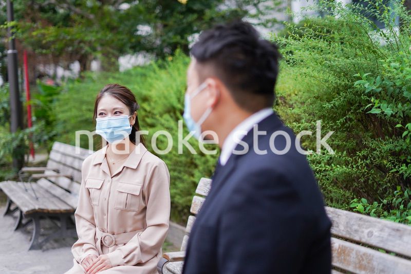 ソーシャルディスタンスを確保して会話をするビジネスパーソン