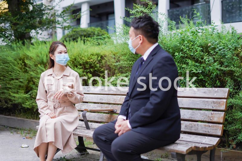 ソーシャルディスタンスを確保して会話をするビジネスパーソン