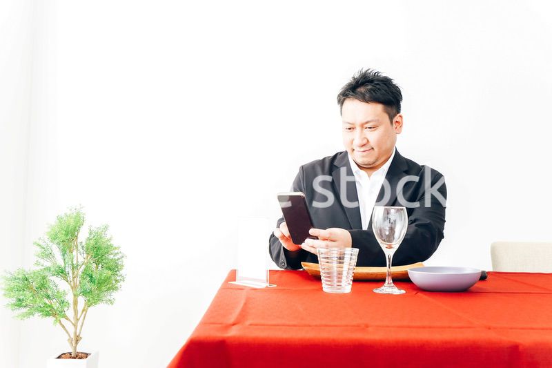 レストランでスマホ決済をする男性