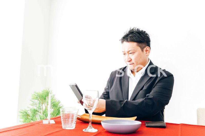 レストランでスマホ決済をする男性