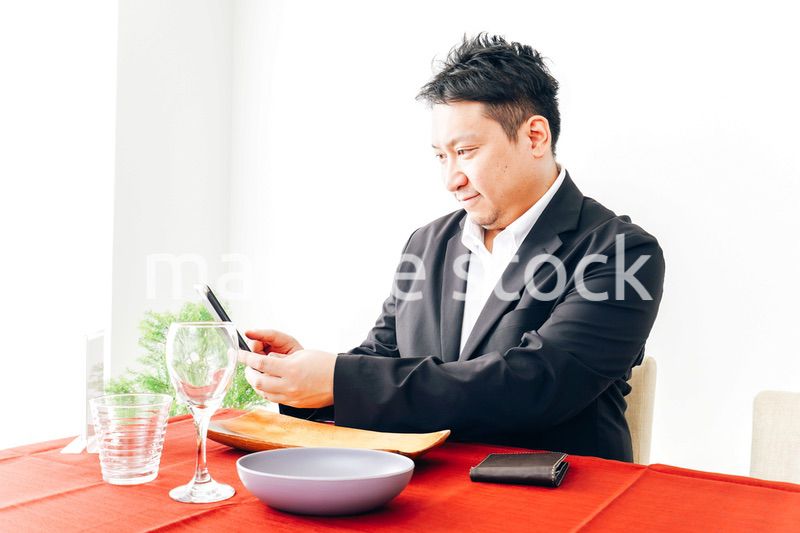 レストランでスマホ決済をする男性