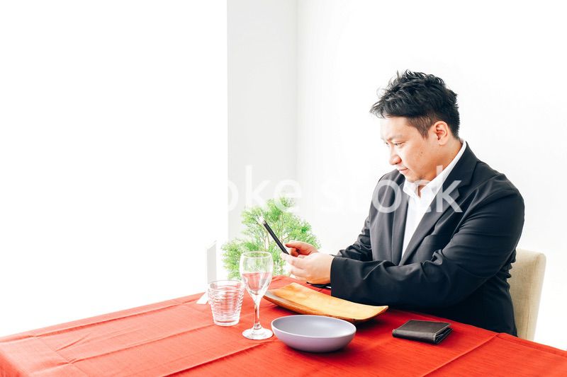 レストランでスマホ決済をする男性