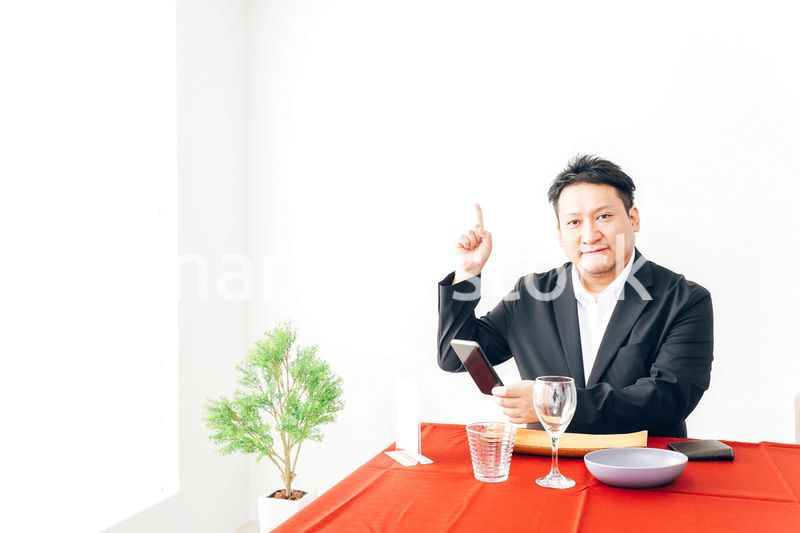 レストランでスマホ決済をする男性