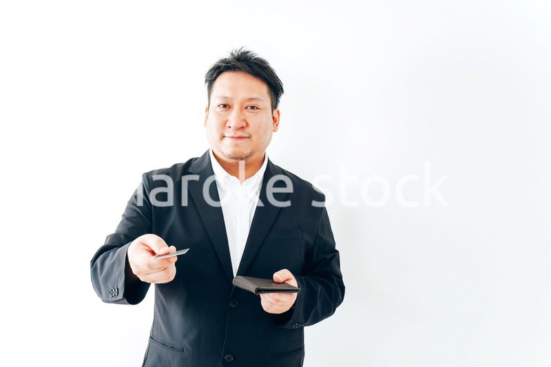 クレジットカード決済をするスーツを着た男性