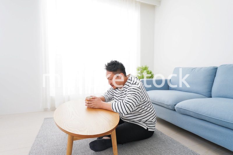 部屋でお茶を飲む中年男性