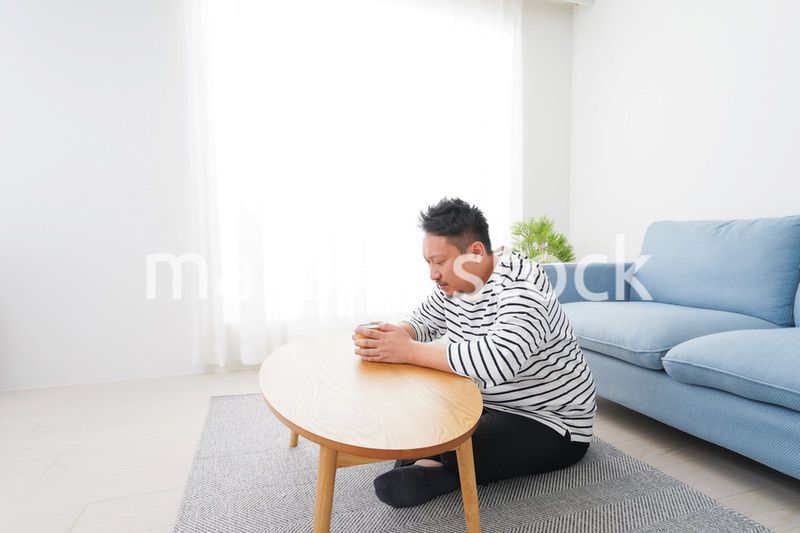部屋でお茶を飲む中年男性