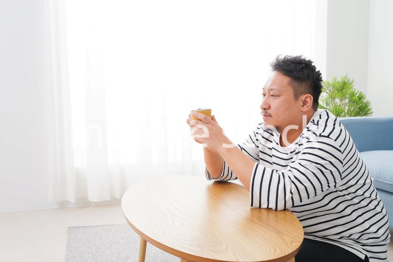 部屋でお茶を飲む中年男性