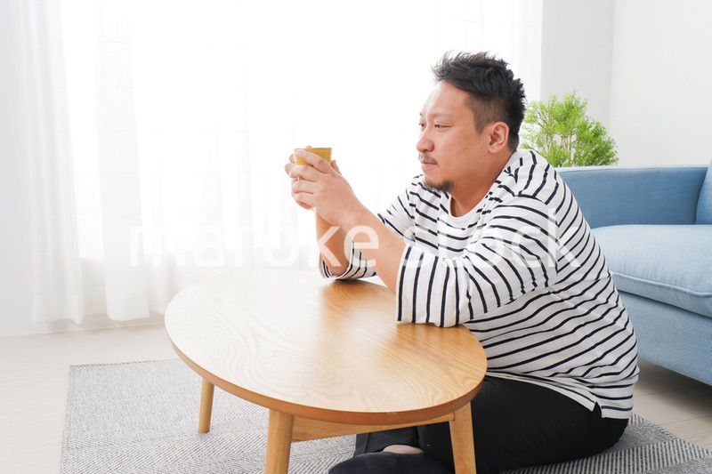 部屋でお茶を飲む中年男性