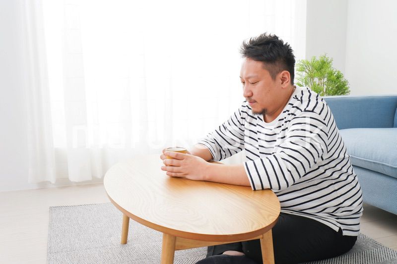部屋でお茶を飲む中年男性