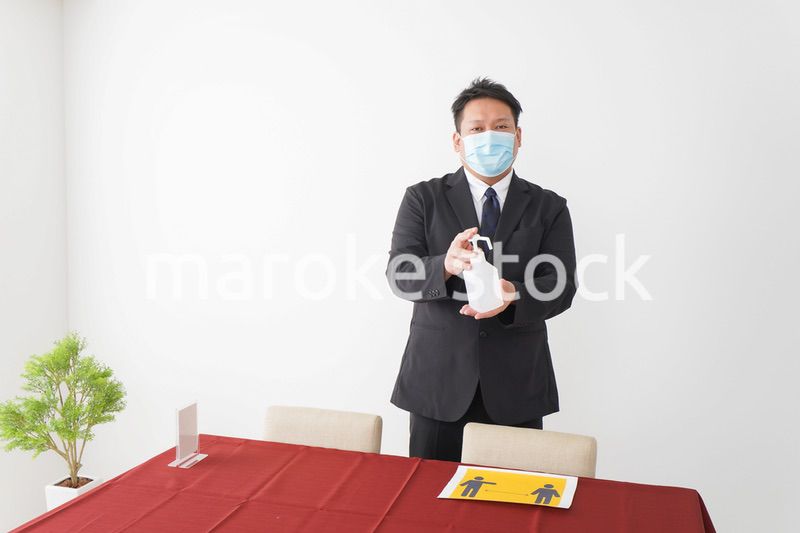 レストランで消毒をお願いするスタッフ