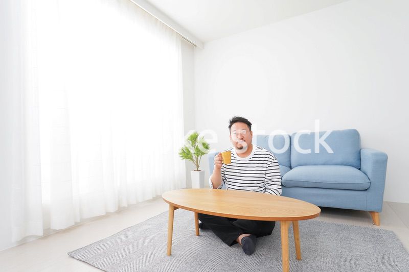 部屋でお茶を飲む中年男性