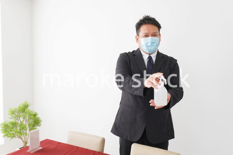 レストランで消毒をお願いするスタッフ