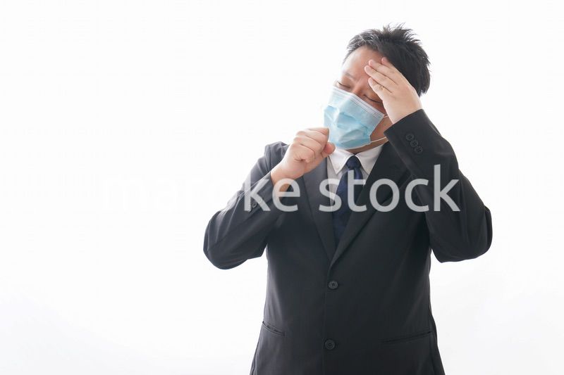 マスクをして咳をする男性
