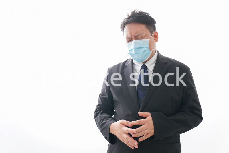 マスクをして腹痛に苦しむ男性