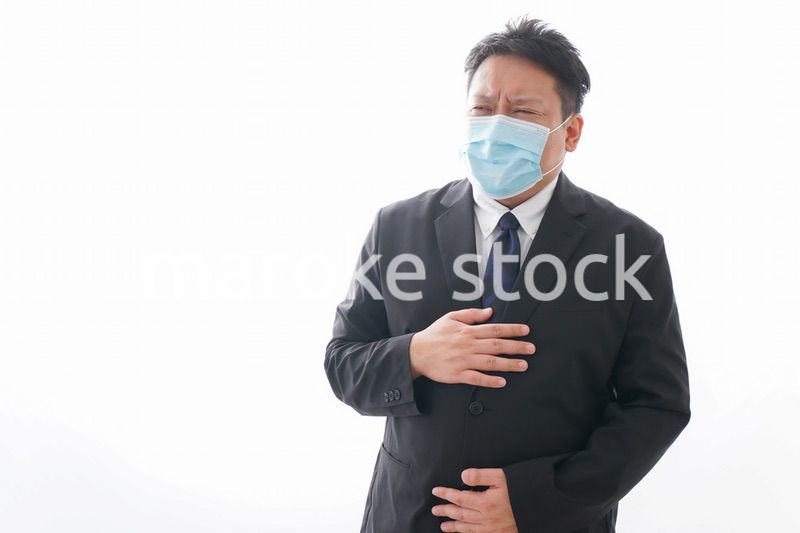 マスクをして腹痛に苦しむ男性