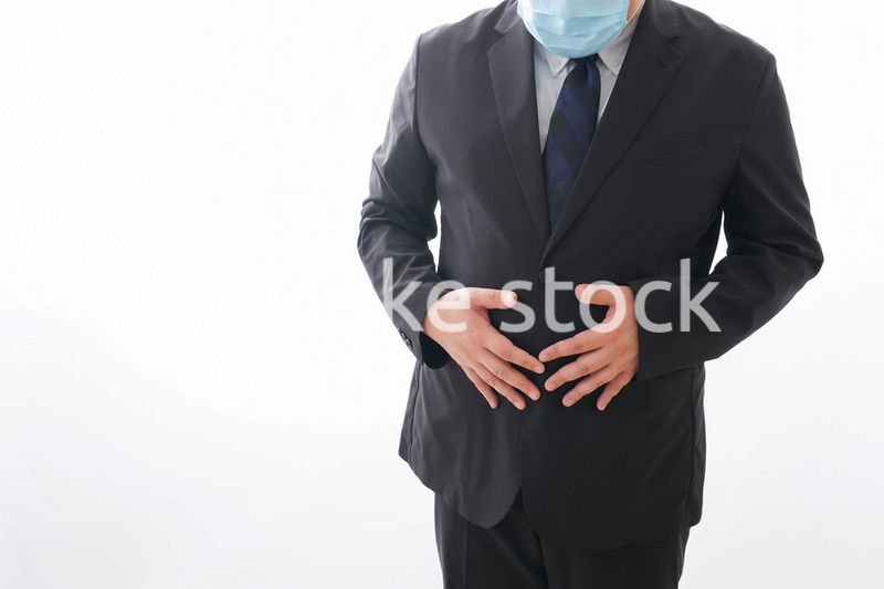 マスクをして腹痛に苦しむ男性