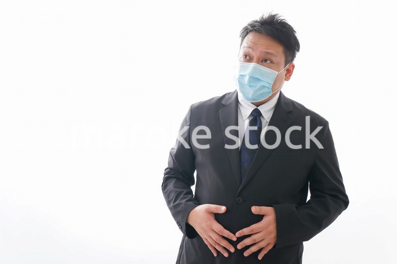 マスクをして腹痛に苦しむ男性