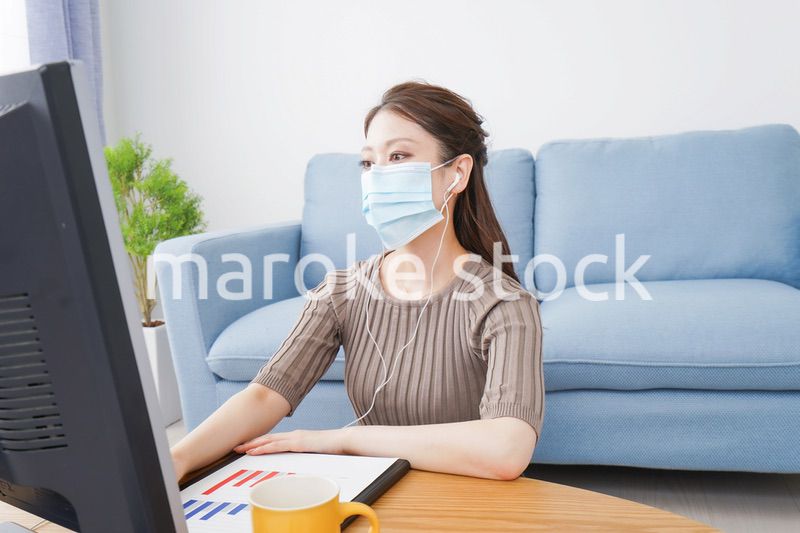 マスクをしてオンライン会議に参加する若いビジネスウーマン
