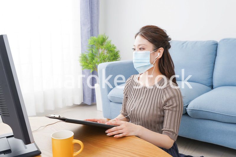 マスクをしてオンライン会議に参加する若いビジネスウーマン