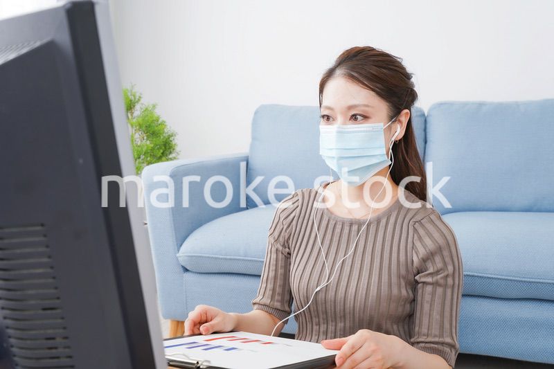 マスクをしてオンライン会議に参加する若いビジネスウーマン
