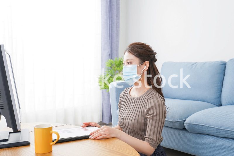 マスクをしてオンライン会議に参加する若いビジネスウーマン