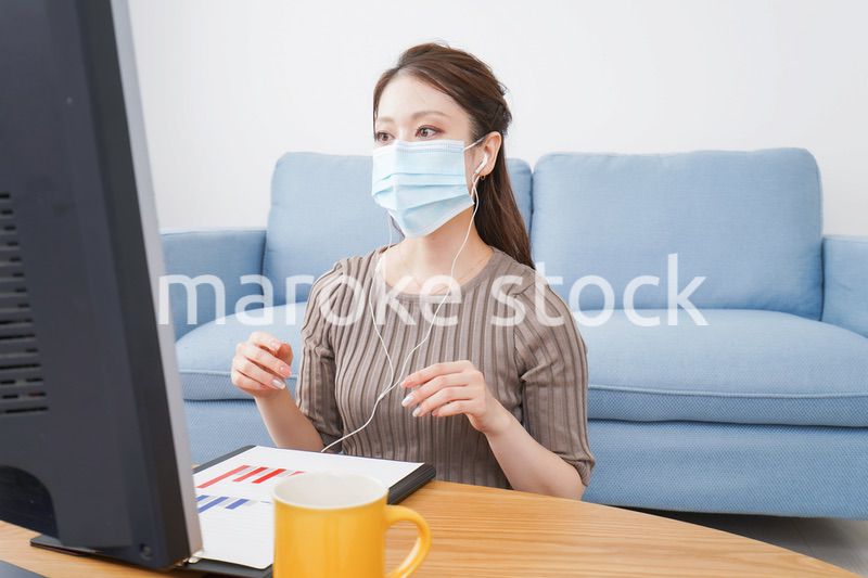 マスクをしてオンライン会議に参加する若いビジネスウーマン