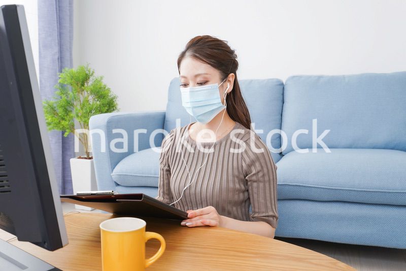マスクをしてオンライン会議に参加する若いビジネスウーマン