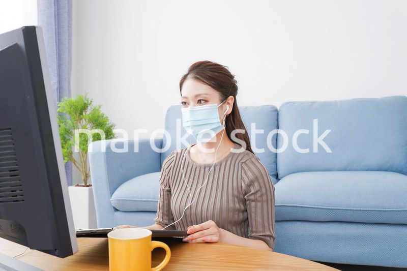 マスクをしてオンライン会議に参加する若いビジネスウーマン