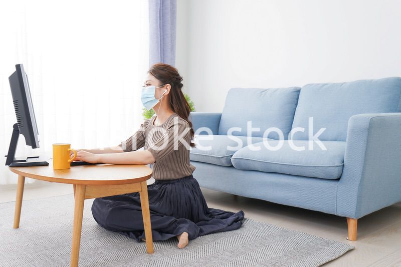 マスクをしてオンライン会議に参加する若いビジネスウーマン