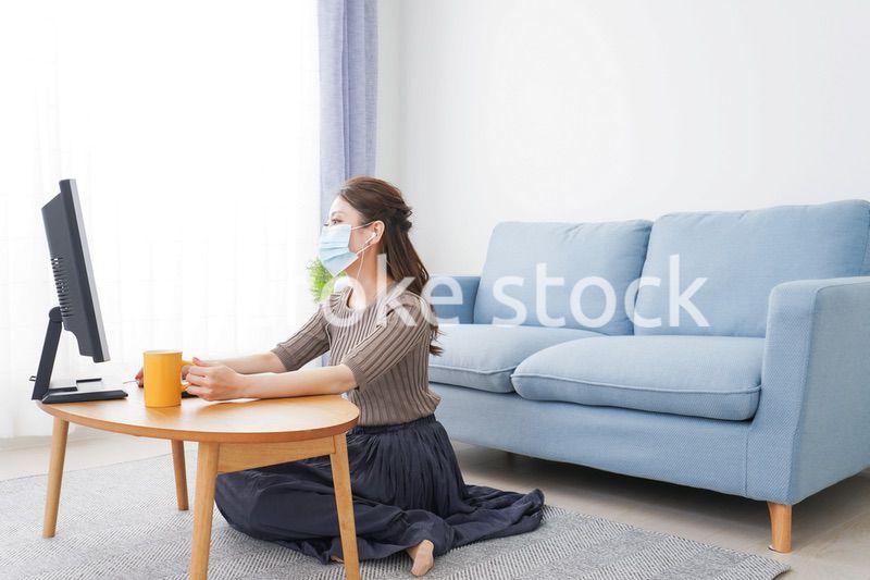 マスクをしてオンライン会議に参加する若いビジネスウーマン