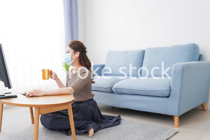 マスクをしてオンライン会議に参加する若いビジネスウーマン