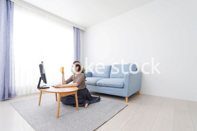 マスクをしてオンライン会議に参加する若いビジネスウーマン