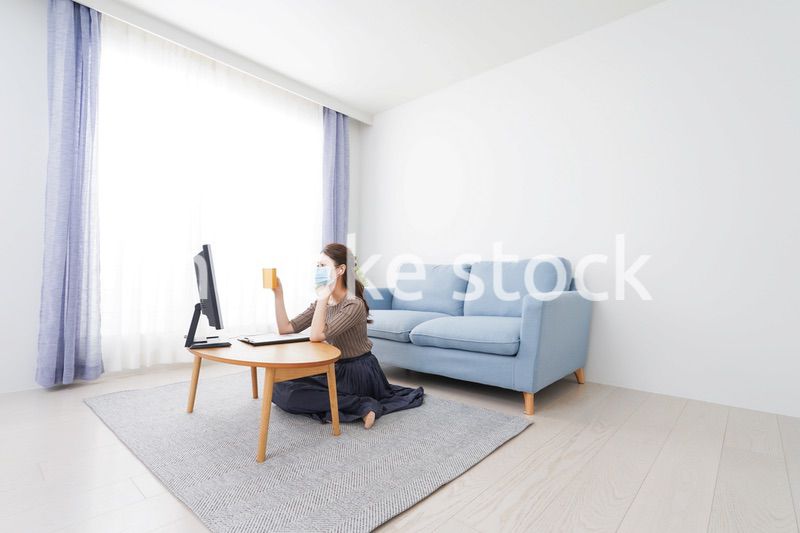 マスクをしてオンライン会議に参加する若いビジネスウーマン