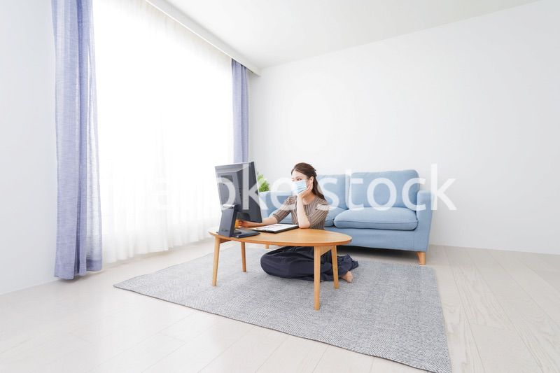 マスクをしてオンライン会議に参加する若いビジネスウーマン