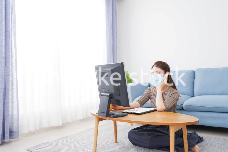 マスクをしてオンライン会議に参加する若いビジネスウーマン