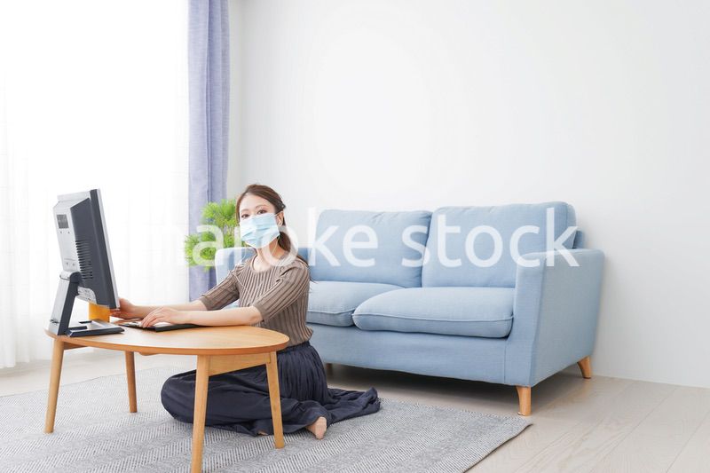 マスクをしてオンライン会議に参加する若いビジネスウーマン