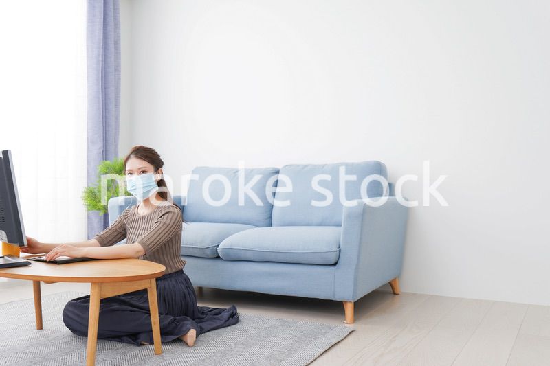マスクをしてオンライン会議に参加する若いビジネスウーマン