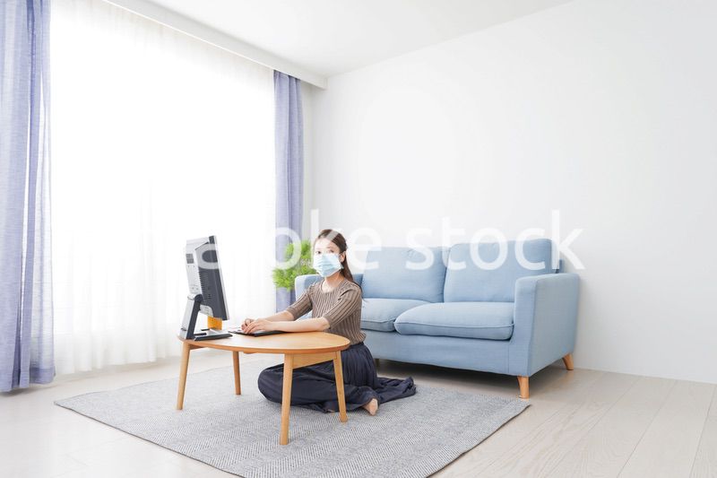 マスクをしてオンライン会議に参加する若いビジネスウーマン