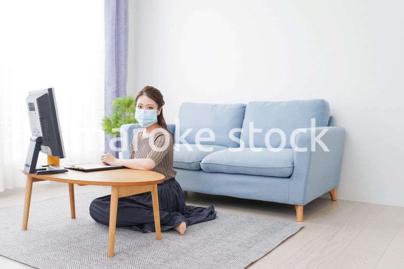 マスクをしてオンライン会議に参加する若いビジネスウーマン