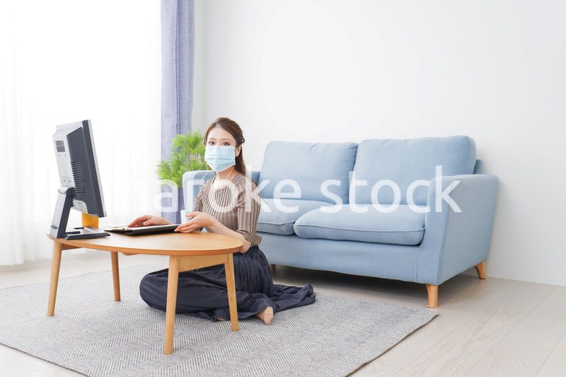 マスクをしてオンライン会議に参加する若いビジネスウーマン