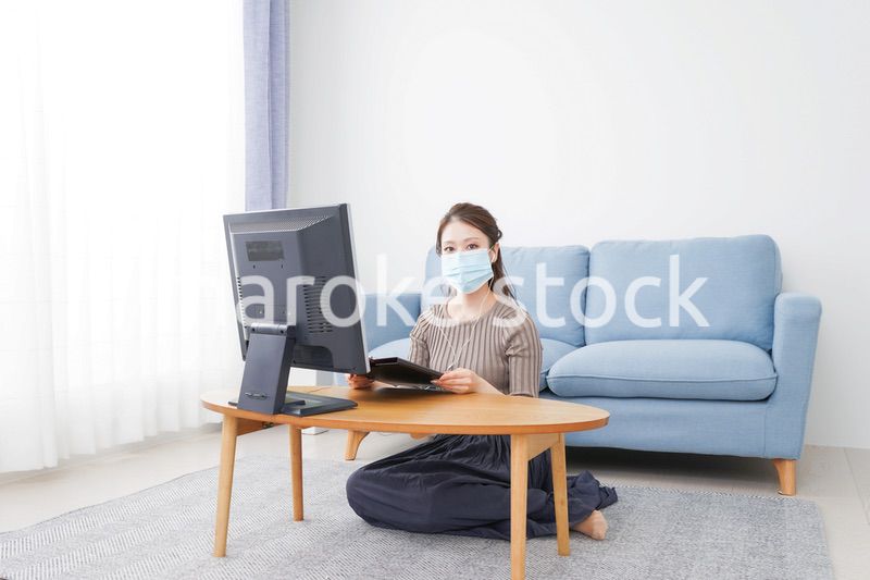 マスクをしてオンライン会議に参加する若いビジネスウーマン