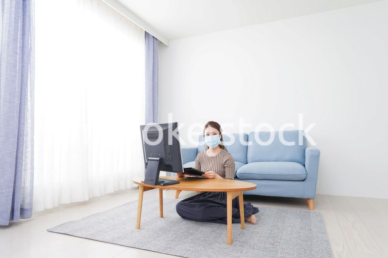 マスクをしてオンライン会議に参加する若いビジネスウーマン