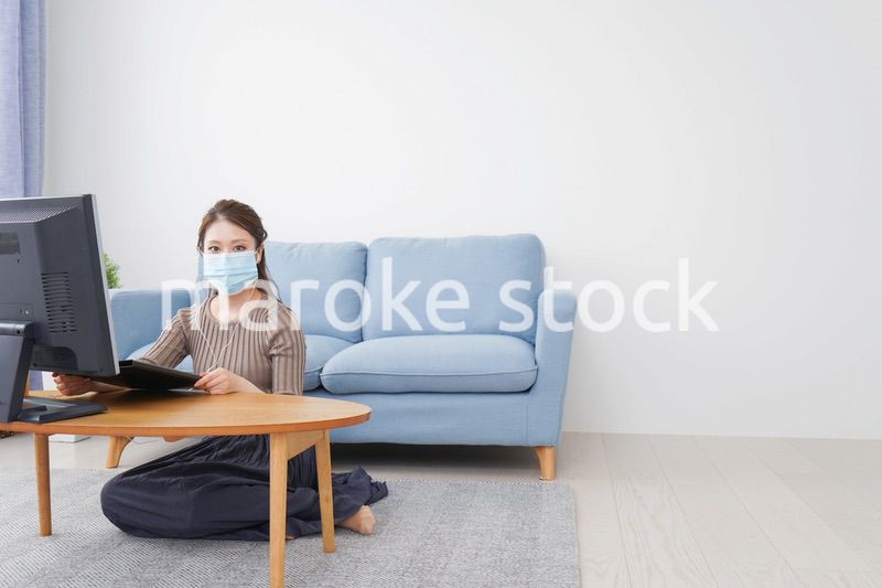 マスクをしてオンライン会議に参加する若いビジネスウーマン