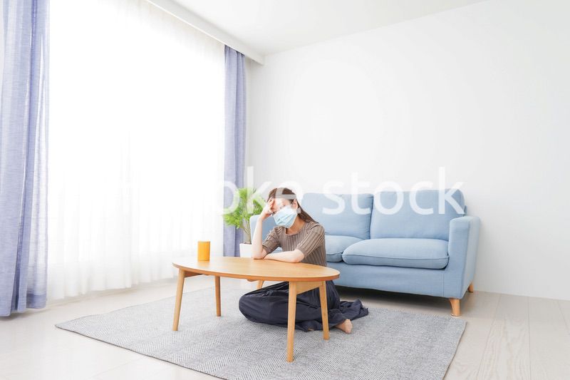 体調不良に苦しむマスクをつけた女性