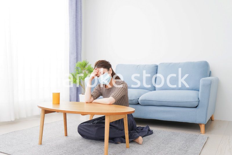 体調不良に苦しむマスクをつけた女性
