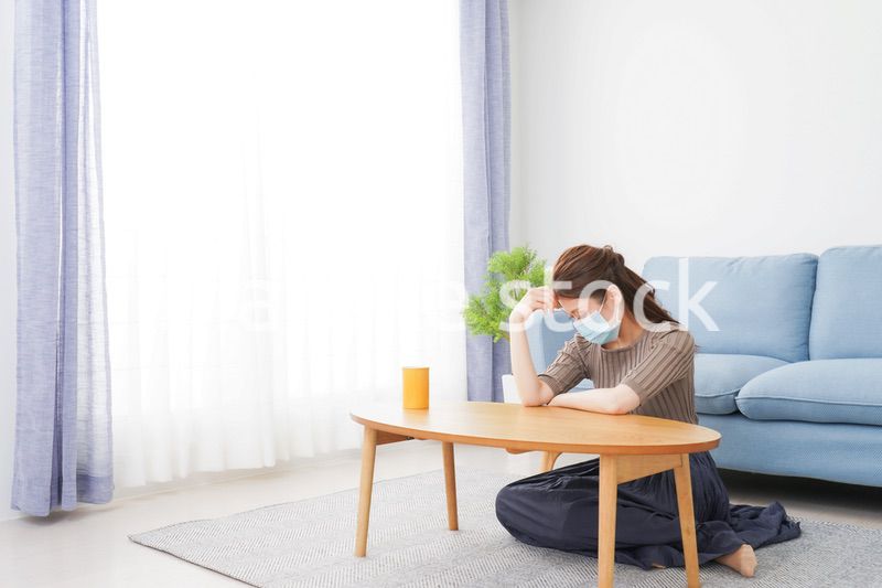 体調不良に苦しむマスクをつけた女性