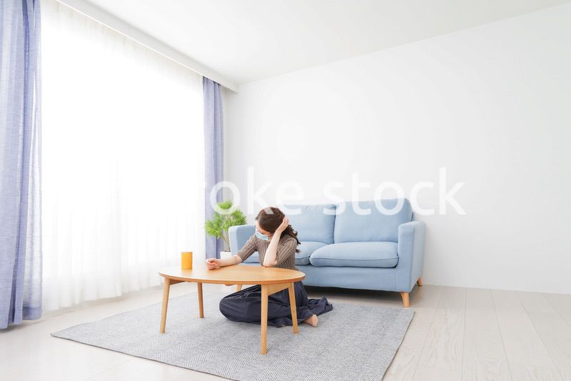 体調不良に苦しむマスクをつけた女性