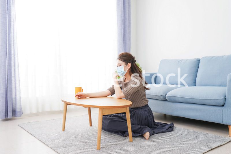 体調不良に苦しむマスクをつけた女性